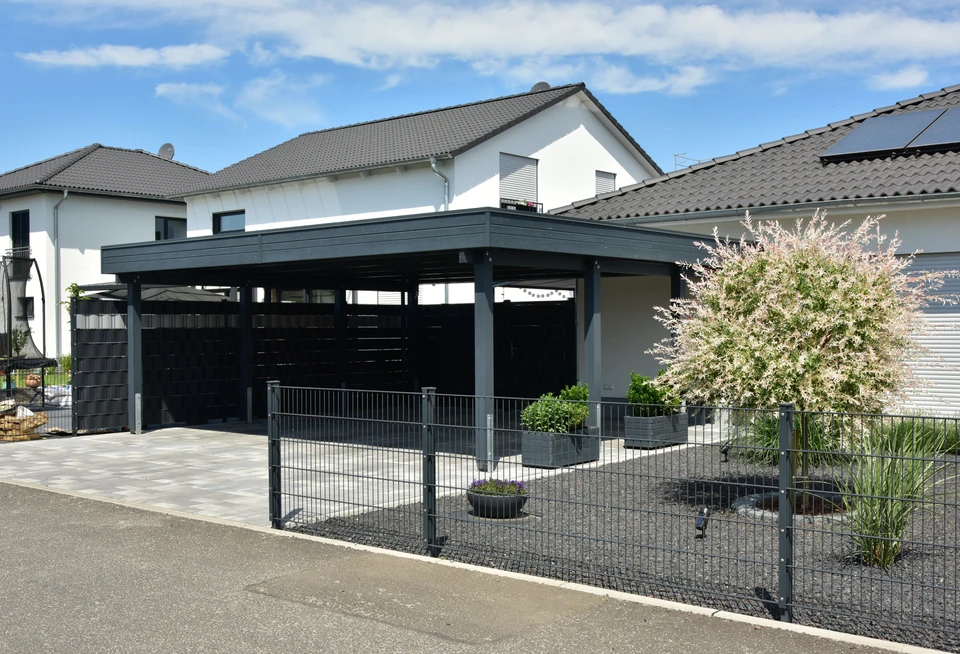 Carport double en acier anthracite avec toiture plate, intégrant un claustra en lames de bois massif horizontal sur les côtés