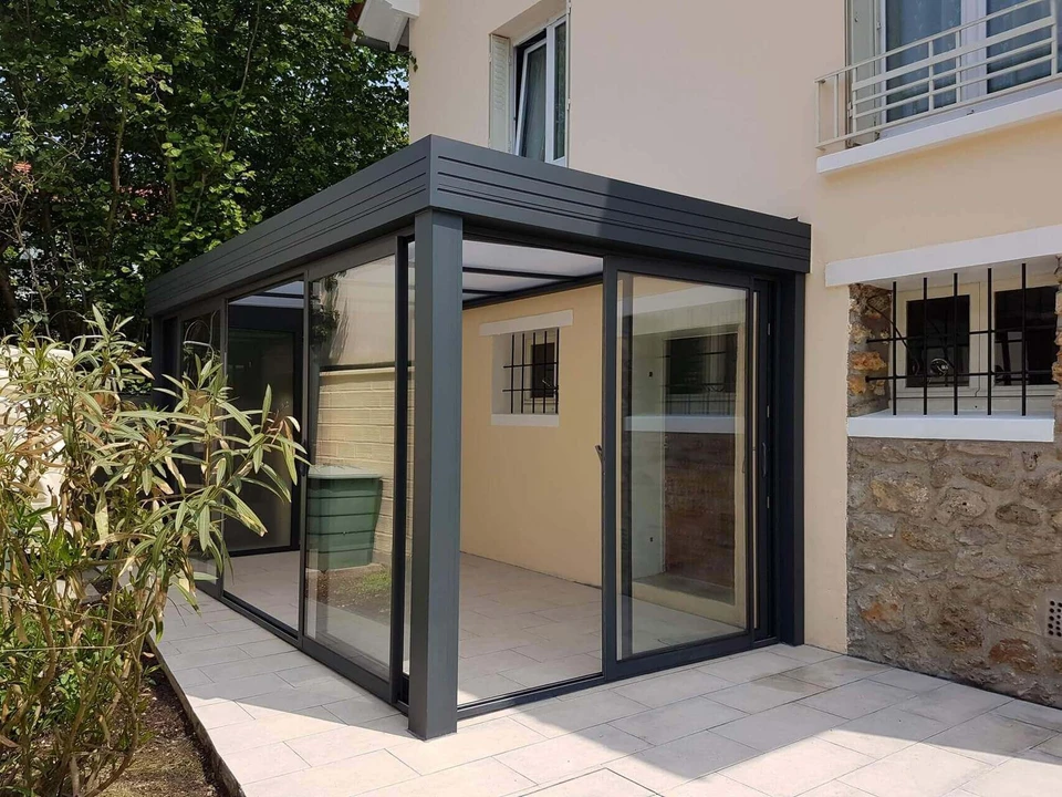 Carport double en acier anthracite avec toiture plate, intégrant un claustra en lames de bois massif horizontal sur les côtés